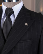 Close-up of a black stripe suit with a wooden hand wearing a white shirt cuff, featuring a 'French Cuff' label.